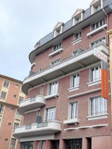 a large red brick building with a sign on it at Studio détente proche Sanctuaires in Lourdes