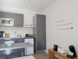 a small kitchen with a counter and a microwave at Studio détente proche Sanctuaires in Lourdes +9 photos