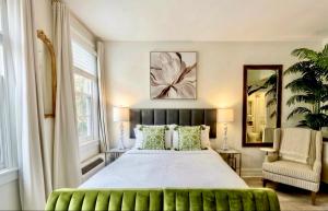 a bedroom with a large bed and a chair at The Green Room - Pool View with Parking Spot at 1920s Historic Residence with 24x7 Reception Desk on Palm Beach Island in Palm Beach +16 photos