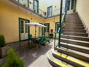 a patio with a table and an umbrella next to a building at Santa Marta Casona in Arequipa