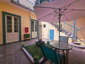 a patio with a table and an umbrella at Santa Marta Casona in Arequipa