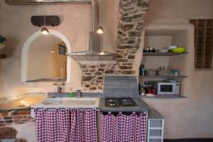 a kitchen with a sink and a stove at Il Nuovo Vecchio Frantoio di Gardan Con Piscina in Vignana