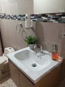 a bathroom with a white sink and a toilet at Hostal Flores in David +74 photos