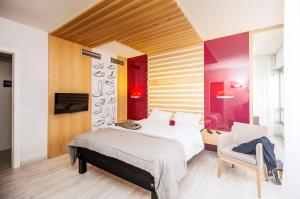 una camera con un grande letto e una sedia di Hotel Ibis Styles La Rioja Arnedo ad Arnedo