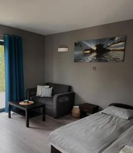 a living room with a bed and a couch at Szum Morza in Wrzosowo