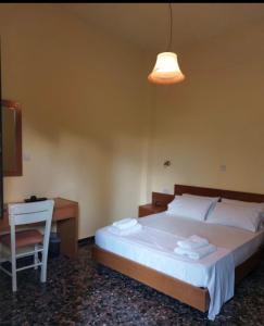 a bedroom with a bed and a desk and a chair at Elafonisos Rooms in Kefálion