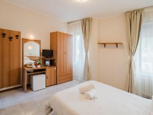 a bedroom with a bed and a desk and a mirror at Hotel Umbria Orvieto-Nuova Gestione- in Orvieto