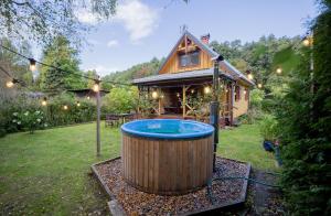 a hot tub in a yard next to a cabin at Dom wakacyjny w kratkę & spa in Białogóra +25 photos