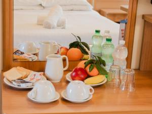 a table with plates of fruit and bottles of milk at Hotel Umbria Orvieto-Nuova Gestione- in Orvieto