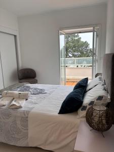 a bedroom with a bed with pillows and a window at Beach House Cabedelo in Viana do Castelo +37 photos