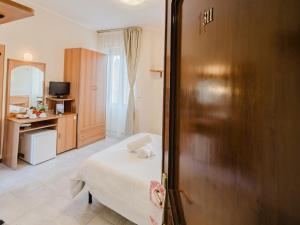 a bedroom with a bed and a desk and a door at Hotel Umbria Orvieto-Nuova Gestione- in Orvieto