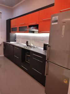 a kitchen with red cabinets and a stainless steel refrigerator at Riverside villa in Qusar