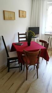 una sala da pranzo con tavolo e sedie rossi di Ferienwohnung Wolf a Gräfenroda