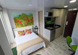 a bedroom with a bed and a painting on the wall at Las Aguas Inner Experience in Bogotá