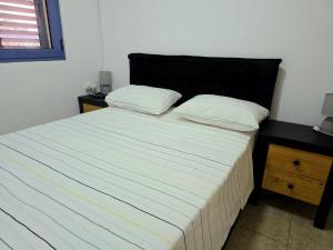 a bed with two pillows on it in a bedroom at Next to the marina in Ashkelon