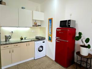 a kitchen with a red refrigerator and a washing machine at Next to the marina in Ashkelon +13 photos