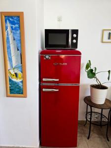a red refrigerator with a microwave on top of it at Next to the marina in Ashkelon