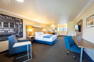 a hotel room with a bed and a desk and chairs at Cayucos Beach Inn in Cayucos