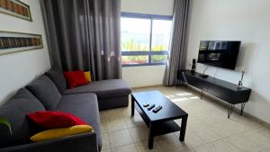 a living room with a couch and a table at Next to the marina in Ashkelon