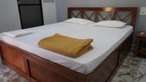 a bed with a yellow blanket on top of it at Hotel Akshada & Guest House in Banda