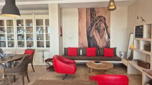 a living room with a couch and red chairs at Anima Ocean Lodges in Essaouira