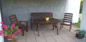 a wooden table and two chairs and a table with flowers at Chalupa u dubu Horní Ostrovec in Písek