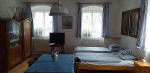 a bedroom with a bed and a table and windows at Chalupa u dubu Horní Ostrovec in Písek