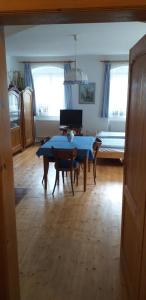 a living room with a table and a bed at Chalupa u dubu Horní Ostrovec in Písek +17 photos
