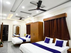 a hotel room with two beds and a ceiling fan at Hotel G17 and Restaurant in Dhāmnod