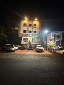 a hotel with cars parked in a parking lot at night at Hotel G17 and Restaurant in Dhāmnod +13 photos