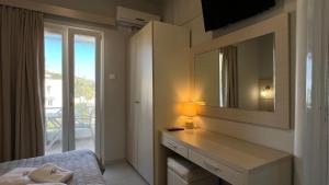 a bedroom with a vanity with a mirror and a bed at Thealos in Azolimnos Syros