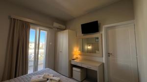 a bedroom with a bed and a desk and a window at Thealos in Azolimnos Syros