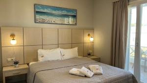 a bedroom with a bed with two towels on it at Thealos in Azolimnos Syros