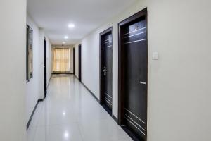 a hallway with black doors and a tile floor at Collection O Lotus Grand in Hyderabad
