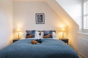 a bedroom with a bed with a tray of food on it at Gad About in Woodbridge