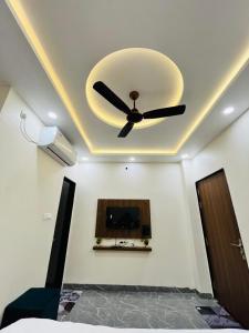 a ceiling fan in a room with a tv at Hotel G17 and Restaurant in Dhāmnod