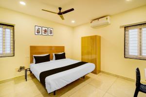 a bedroom with a bed and a ceiling fan at Super Hotel O Nivara in Hyderabad