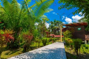 a path in a garden with trees and a building at Villa Jennifer in Tingo María