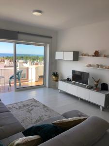 a living room with a couch and a television at Beach House Cabedelo in Viana do Castelo