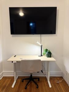 a desk with a chair and a television on a wall at The Broadway Escape - Private Room in Times Square in New York +12 photos