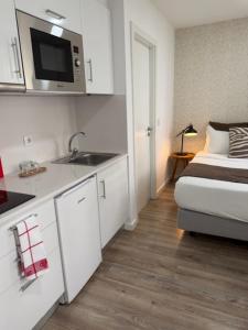 a kitchen with a sink and a bed in a room at Jardim da Trindade in Coimbra