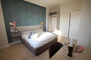 a bedroom with a bed and a table with a bottle of wine at I Settembrini in Capo Vaticano