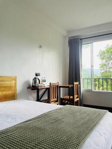 ein Schlafzimmer mit einem Bett, einem Tisch und einem Fenster in der Unterkunft Crystal Resort in Badulla