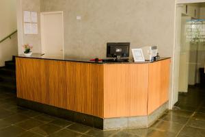 a reception desk with a computer on top of it at Novo Maanaim Hotel in Presidente Epitácio