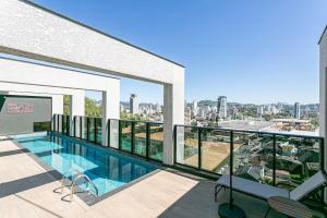 a swimming pool on the balcony of a building at Loft Completo com Piscina Aquecida 250m da Vila Germânica in Blumenau