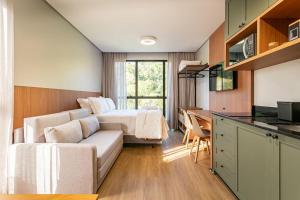 a living room with a couch and a bed at Loft Completo com Piscina Aquecida 250m da Vila Germânica in Blumenau