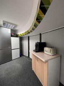 a kitchen with a counter with a microwave and a refrigerator at GIRLSTEL Wrocław - Girls ONLY Space in Wrocław