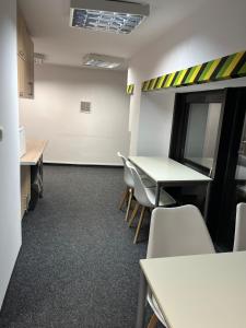 an office with tables and chairs and a white wall at GIRLSTEL Wrocław - Girls ONLY Space in Wrocław