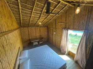 a bed in a room with a table and a window at Bamboo Life in Dera Gopipur