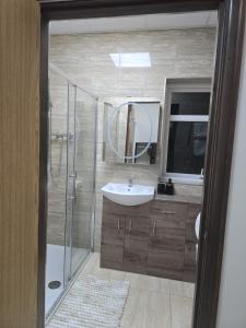 a bathroom with a sink and a shower with a mirror at Allen's property with Air conditioner in Birmingham